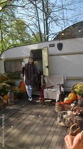 On a cozy day, a stylish and beautiful woman in hippie attire talks about life in a trailer while sipping a hot drink.