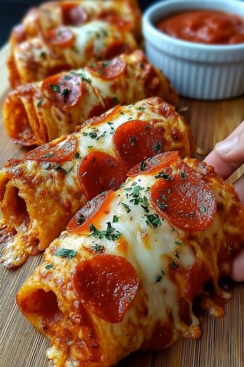 DELICIOUS CHEESY PEPPERONI PIZZA ROLL-UPS RECIPE 🍕🧀 🧾 Ingredients: 1 can refrigerated pizza dough (or crescent dough) 1 cup shredded mozzarella cheese 1/2 cup mini or regular pepperoni slices 2 tbsp grated Parmesan cheese 1/2 tsp garlic powder 1/2 tsp Italian seasoning 1 tbsp melted butter (optional, for brushing) Marinara or pizza sauce (for dipping) 🍳 Instructions: Preheat Oven: Preheat to 375°F (190°C). Line a baking sheet with parchment paper. Roll Out the Dough: Unroll the pizza dough a