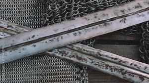 Crossed swords on chain armor, close up, historical ancient weapon concept