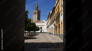 POV walkthrough doorway heading towards Seville Cathedral's Moorish Giralda tower, Sevilla, Andalusia, Spain