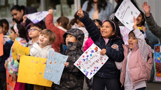 School children at Regent Road Elementary School in Surrey, B.C., hold signs and cheer on Wednesday as they welcome peers displaced by fire.