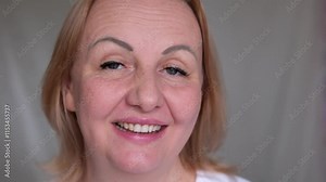 woman nodding her head in agreement Satisfied woman smiling and nodding her head in agreement expressing her approval and satisfaction with deal while posing against gray background