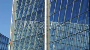 Skyscraper Window Cleaning conducted by Harnessed Workers in a bustling urban environment