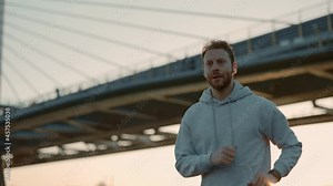 Male runner using earphone and fitness tracker outdoors
