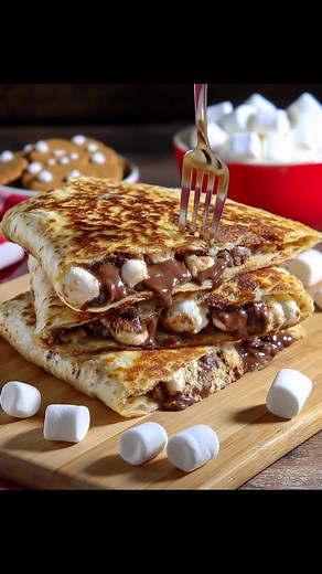 There’s something magical about combining crunchy graham crackers, gooey marshmallows, and rich chocolate all wrapped up in a warm tortilla. One bite of these S'mores Crunchwraps and you’ll be transported back to those carefree campfire nights! Recipe’s waiting for you in the comment 👇 | Recipes & Cooking Guide
