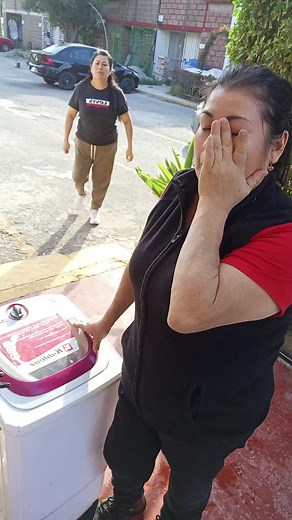 Loading Clothes into a Washing Machine Outdoors