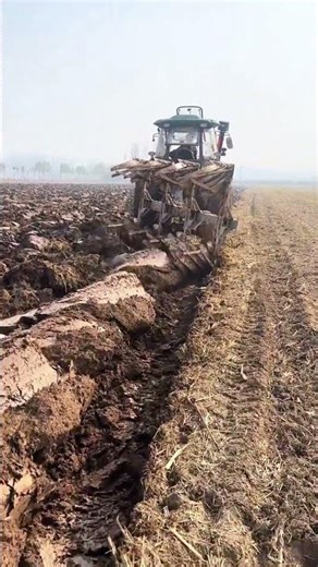 Agricultural Power: Deep Plowing a Vast Field with a Huge Tractor