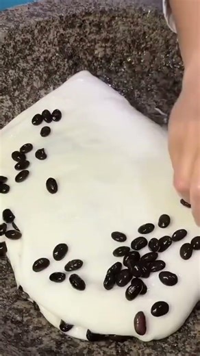 making mochi dough by pounding it with wood repeatedly until the texture is smooth and chewy