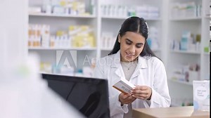 Pharmacist working on computer at a pharmacy with pills to check order online. Woman with technology to access medical database, inventory check and online medicine prescription in a healthcare store