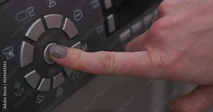Female hand presses button on control panel on washing machine. Close-up. Starting home appliances for washing