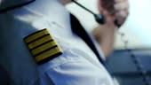 Serious captain of airliner transmitting information by radio, job...