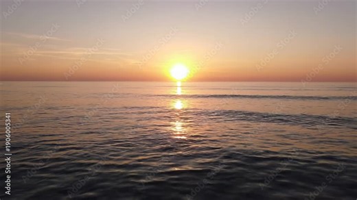 Beautiful ocean sunset with the sun reflecting on the water's surface, creating a golden path, calming waves.