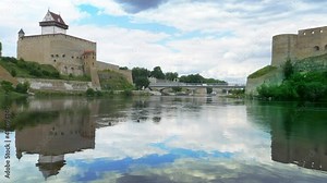 Historic landmarks on Russian Estonian border, Narva Herman castle and Ivangorod fortress on banks of Narva river, cloudy sky horizon vista