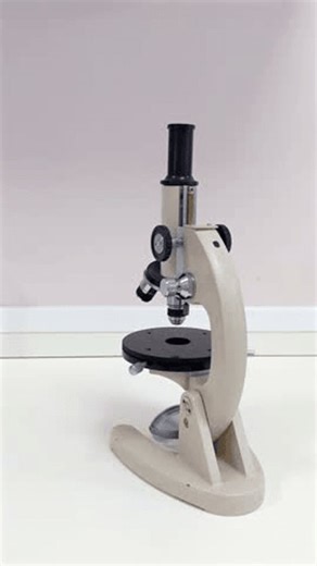 clip-4004979739-gloved-hand-lab-coat-turns-focus-knob