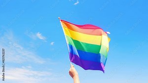 Rainbow flags showing in hands against clear blue sky, People to support and respect the gender diversity, Human rights and to celebrate lgbtq+ in pride month