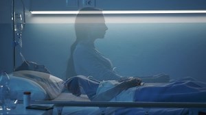 Female patient sleeping in a hospital bed at night, her soul leaves her body and goes away, near death experience concept