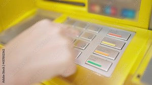 Side view of caucasian woman hand entering put the passcode on the ATM machine keypad at the bank. Use personal identification number. Finance, technology and security concept.