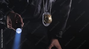 Police officer at night with a flashlight in his hand trying to look after something.