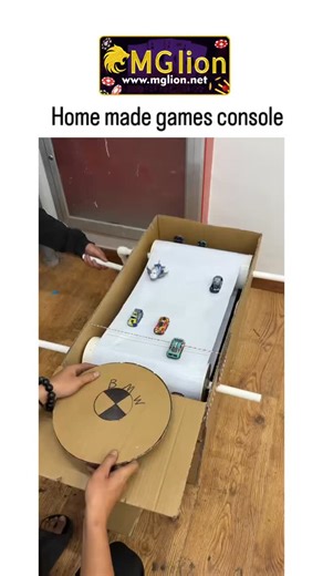 bio life 🧬 on Instagram: "Home made games console KINDLY DM FOR CREDIT AND REMOVAL #mglion #csmediain It features a short video showing a very creative, low-tech homemade gaming device built mostly from cardboard and simple materials. The "console" is a handheld unit with a crank mechanism (like an old-school film reel or music box style) that you manually turn by hand to scroll through and "play" a scrolling game scene — it looks like a basic endless runner or side-scroller with pixel-art styl