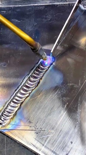 welding two flat metal sheets together precisely using a bright blue gas torch welder