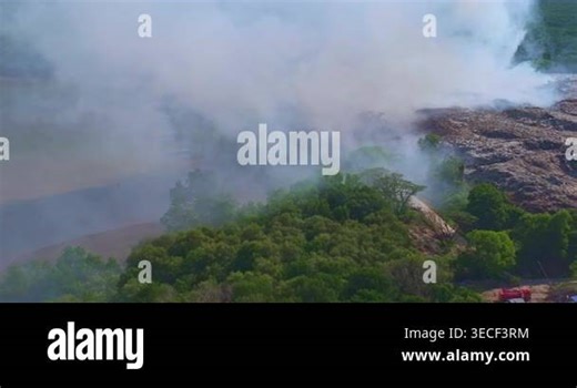 Aerial view of white smoke billowing from a burning landfill in Phuket city, highlighting environmental pollution and waste management issues. Fire at large waste incineration plant in Phuket Stock Video Footage - Alamy