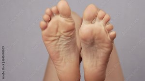 Close up woman wiggles fingers toes while lying on bed in room. Female is moving limbs feet does gymnastics at medical center. Compression, unclenching of limbs, feet. Relief from cramps, stress