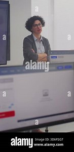 Female Teacher Stands By Large Screen Displaying Programming Code, Explaining Modeling Concepts to Adult Students. Digital Education, Coding Skills, Professional Learning Environment. Vertical Shot.