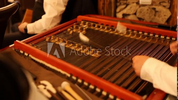 Folk musician performing with cimbalom in cozy tavern setting