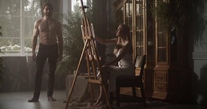 Male model with naked torso posing for artist in workshop