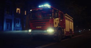 Night is Lit Up by the Flashing Emergency Lights of a Fire Truck, Rolling Through the Dark Streets in Response to an Incident. Vehicle Speeds Through the City on a Mission to Save Lives
