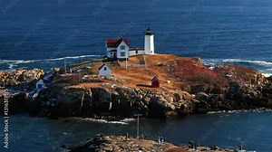 The Maine Lighthouse called Nubble Lighthouse is located at the Cape Neddick rock with deep blue sky background