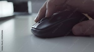 Close-up of Hand Browsing Internet using Wireless Mouse. Scrolls Websites and Clicks while Moving the Mouse on White Table.