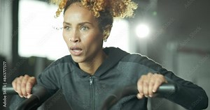 Fitness, gym and woman on bike machine for health, wellness and weightloss workout training. Endurance, active and female athlete on electric bicycle equipment for cardio exercise in sports center.