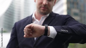 Close up of business man checking time for being on time in important appointment or meeting. Manager in a hurry while looking at watch and waiting for his teammate or colleague. Life style. Urbane.