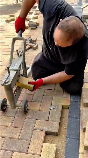 Construction Work Laying Interlocking Pavers and Using a Block Cutter for Precision Fitting