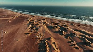 Aerial drone view of the ocean shore beaches next to the Namib dunes on a beautiful day of adventure at sunset, Namibia, Africa Stock Video