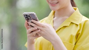 Happy cute girl using map application on mobile phone while standing on modern city background.