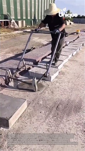 Concrete block laying machine: worker using a machine to lay concrete blocks