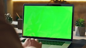 Unknown worker scrolling touchpad green screen laptop at modern workplace close up. Manager hand using computer keyboard searching data in internet indoors. Businessman working at mockup notebook.