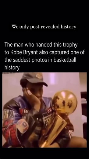 HISTORY on Instagram: "The image of Kobe Bryant holding the 2001 NBA championship trophy is far more than just a celebration shot. The photo - showing the young star sitting alone in the locker room, trophy in hand, his face marked by quiet reflection - captures both the triumph of victory and the weight of his personal struggles at that time. In 2001, Kobe and the Los Angeles Lakers had just secured their second consecutive NBA title, cementing their dynasty. But off the court, his life was far
