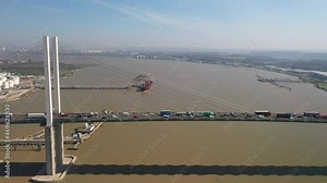 Tall concrete pylon and cables supporting bridge with heavy traffic