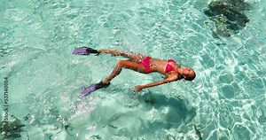 Vacation travel - snorkel woman swimming in clear pristine water relaxing on her back wearing red bikini and pink snorkeling fins. Beautiful beach reef lagoon top view Stock Video