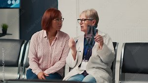Senior medic and asian woman analyzing x ray scan in clinic lobby, looking at bones radiography result to explain medical diagnosis and disease. People taking about healthcare medicine.