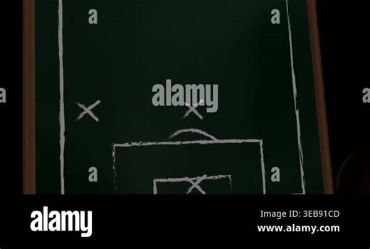 Male player reacting to ball rolling, kicking across board overlapping X marks to show soccer play. Chalkboard, tactic, arrows, pitch, diagram, training, studio