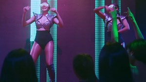 Group of people dance in disco night club to the beat of music from DJ on stage | Premium Stock Video Footage