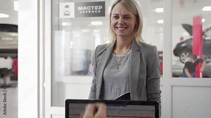 Client hands over vehicle keys to service representative at auto repair shop. Professional smiling woman accepts car key for maintenance. Male customer at car service center for checkup.