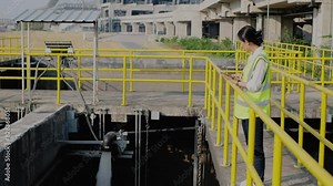 service engineer checking on waste water treatment plant with pump on background. worker working on Waste water plant.