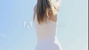 Carefree romantic lady tourist dancing on sunset sea cliffs zoom on. Relaxed serene woman enjoying stormy seascape at weekend closeup. Girl moving body seductively at beach wearing dress