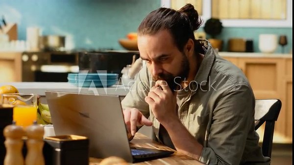 Confused disoriented man being uncertain about task completion, frowning at laptop screen while he works from home. Ambiguous misunderstanding information and person in doubt.