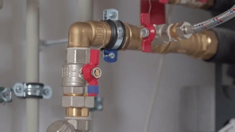 clip-3965459885-close-up-technician-hand-adjusting-valve-on-heat